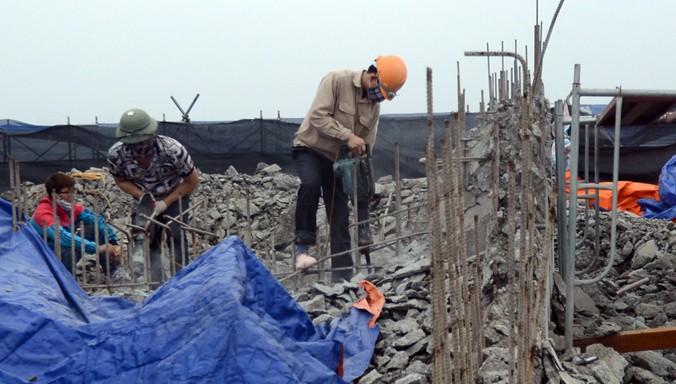 Công nhân đang phá dỡ “cắt ngọn” tòa nhà 8B Lê Trực. Ảnh: Dân Trí