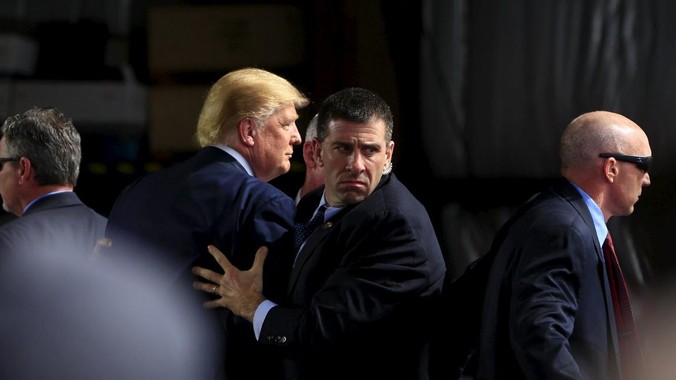 Các đặc vụ che chắn cho ứng viên Donald Trump (thứ hai từ trái sang) khi một người đàn ông cố vượt qua hàng rào an ninh khi ông Trump phát biểu ở Ohio. Ảnh: AP