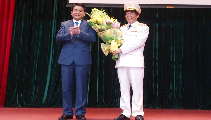 Chủ tịch UBND thành phố Hà Nội Nguyễn Đức Chung tặng hoa chúc mừng tân Giám đốc Công an thành phố Hà Nội Đoàn Duy Khương (phải).