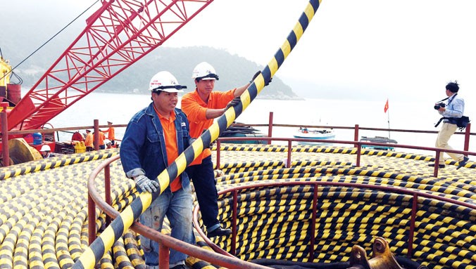 Công nhân thi công kéo cáp ngầm qua biển để cấp điện cho đảo Cù Lao Chàm.