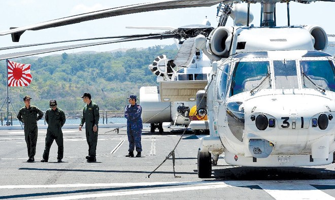 Các phi công Nhật Bản đứng trên tàu sân bay trực thăng Ise của Nhật Bản trước khi tàu vào cảng Subic ở phía bắc thủ đô Manila của Philippines hôm 26/4. Ảnh: Ted Aljibe