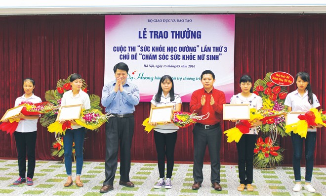 Ông Nguyễn Văn Đình - đại diện nhãn hàng Dạ Hương và ông Đoàn Văn Ninh - Phó vụ trưởng vụ THPT chụp ảnh lưu niệm cùng các em nữ sinh đạt giải.