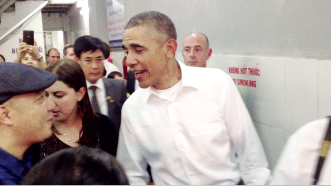 Ông Obama bắt tay phóng viên Hồng Vĩnh, báo Tiền Phong (bìa trái) tại quán bún chả Lê Văn Hưu hôm 23/5. Ảnh: Trường Phong