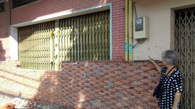 Để ngăn chặn nước mưa tràn vào nhà, người dân xây tường chắn trước nhà.