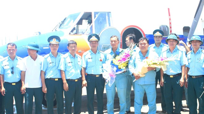 Đồng đội chúc mừng đại tá Lê Kiêm Toàn và thượng tá Nguyễn Đức Hảo (hai người cầm hoa) trở về đơn vị sau khi thực hiện nhiệm vụ bay chuyển sân hạ cánh ở Trường Sa trên một chiếc Casa-212, đầu tháng 6/2016.