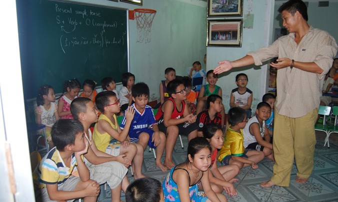 Hùng John trong một buổi dạy tiếng Anh miễn phí cho trẻ em ở Thanh Hóa trong chuyến đi xuyên Việt 2012