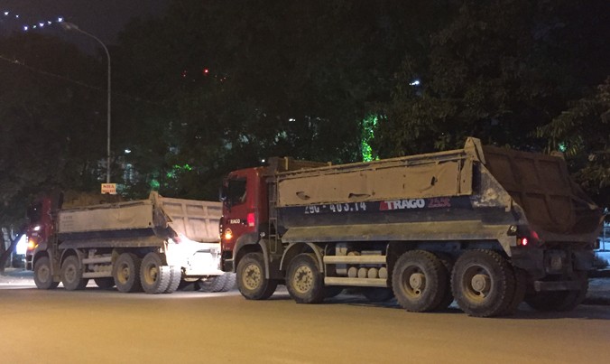 Hàng loạt xe tải nằm chờ hết giờ giới nghiêm trên đường Duy Tân kéo dài (đoạn đối diện công viên Cầu Giấy) chiều tối mỗi ngày né cảnh sát. Ảnh: Nguyễn Hoàn