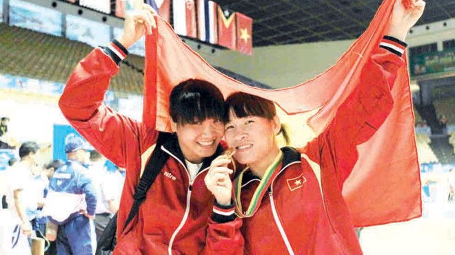 Nguyễn Thị Lụa (phải) mạnh mẽ giành vé đến Olympic dù phải tăng 2 hạng cân thi đấu. Ảnh: VSI