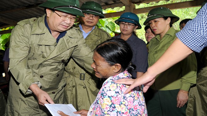 Phó Thủ tướng Trịnh Đình Dũng thăm hỏi và động viên gia đình chị Vàng Hồng Hạnh có 3 con bị lũ cuốn mất tích. Ảnh: Phạm Đức