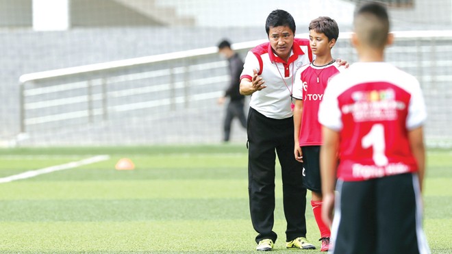 Cựu danh thủ Hồng Sơn hướng dẫn các em thiếu nhi chơi bóng. Ảnh: VSI