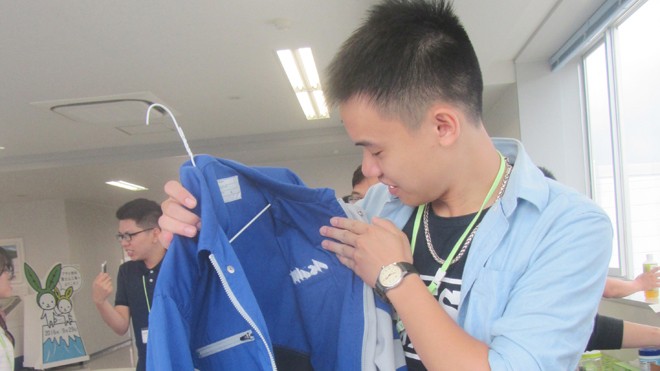 Một bạn trẻ Việt Nam thử chiếc áo đồng phục làm từ chai nước tái chế. Ảnh: Trúc Quỳnh