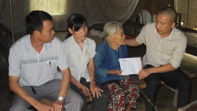 PV Tiền Phong trao tiền cho những người dân nghèo trên địa bàn huyện Hương Khê.