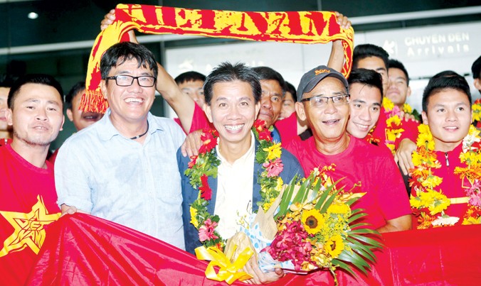 Thầy trò HLV Hoàng Anh Tuấn về tới sân bay Tân Sơn Nhất trong sự chào đón nồng nhiệt của VFF và người hâm mộ. Ảnh: VSI