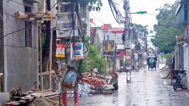 Những chiếc cột điện đứng giữa đường tại xã Vĩnh Quỳnh. Ảnh: K.N