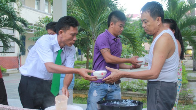 Lê Phú Lâm (đeo cà vạt) cùng những người bạn phát cháo từ thiện tại Bệnh viện Đa khoa Hội An