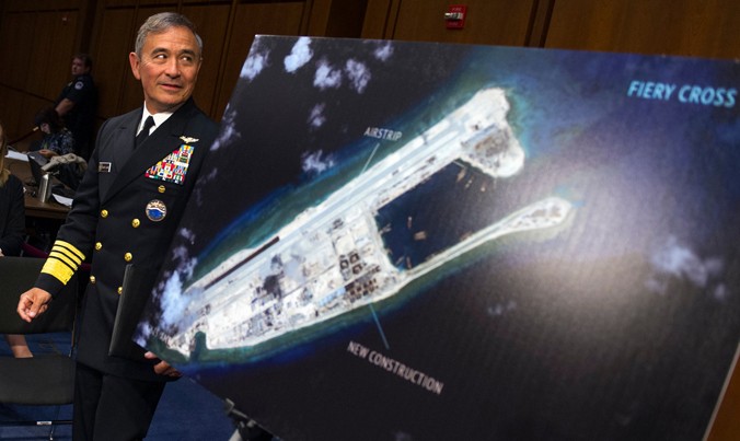 Đô đốc Mỹ Harry Harris đi ngang bức ảnh vệ tinh cho thấy Trung Quốc đang xây dựng trái phép trên đá Chữ Thập (thuộc quần đảo Trường Sa của Việt Nam). Ảnh: AP