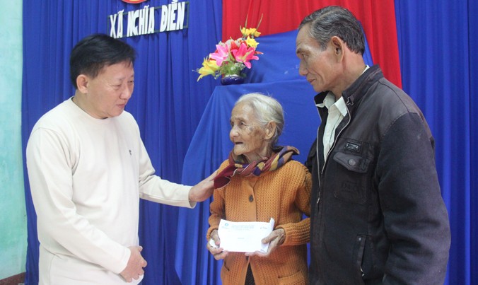 Ông Nguyễn Thanh Tú, Chánh văn phòng, Chủ tịch Công đoàn Cty Vinamilk trao tiền hỗ trợ cho bà Nguyễn Thị Phú có nhà bị sập do mưa lũ.