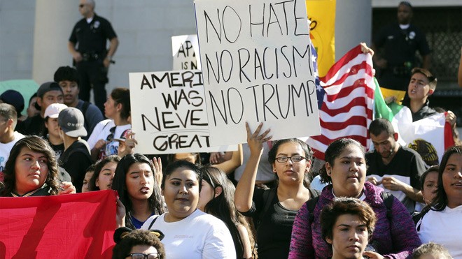 Hàng triệu phụ nữ xuống đường phản đối tân Tổng thống Mỹ Donald Trump. Người phụ nữ đeo kính giơ tấm biển viết: “Không thù hận, không phân biệt chủng tộc, không Trump”. Ảnh: NBC
