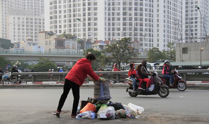 Một người phụ nữ thản nhiên đổ rác ra giữa đường Nguyễn Trãi, đoạn gần cầu vượt Ngã tư Sở (Hà Nội). Ảnh: Trường Phong