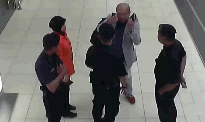 Hình ảnh từ camera giám sát ở sân bay quốc tế Kuala Lumpur cho thấy người đàn ông được cho là ông Kim Jong-nam (áo sáng màu, đeo ba lô) đang nói chuyện với các nhân viên an ninh và cán bộ sân bay sau khi bị đầu độc. Ảnh: AP