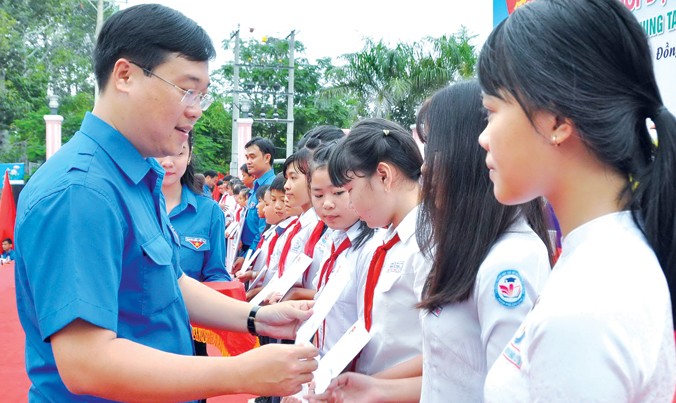 Anh Lê Quốc Phong tặng quà cho học sinh nghèo. Ảnh: Hòa Hội