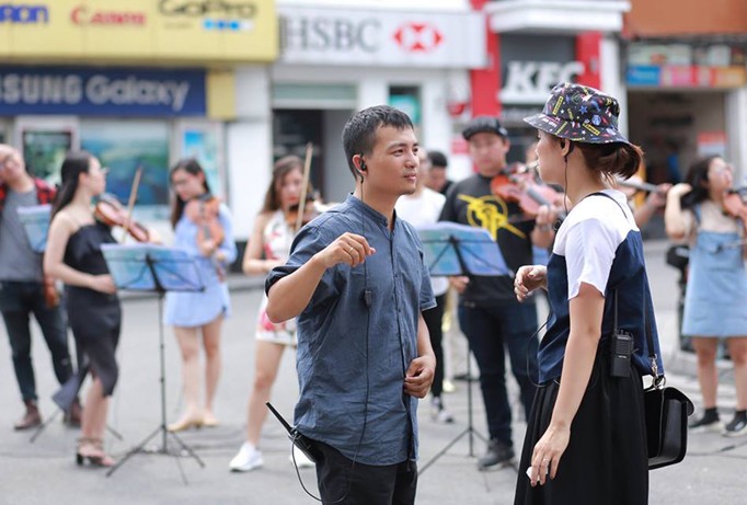 Lưu Quang Minh đang chỉ đạo dàn nhạc biểu diễn trên phố đi bộ Hà Nội.