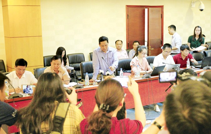 Ông Nguyễn Xuân Quang (đứng giữa) trả lời báo chí xung quanh vụ việc mất tiền. Ảnh: Trường Phong.