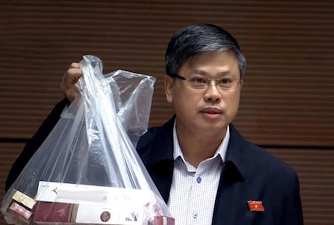 Đại biểu Nguyễn Sỹ Cương với túi thuốc lá lậu mua được trong chuyến đi thực tế.