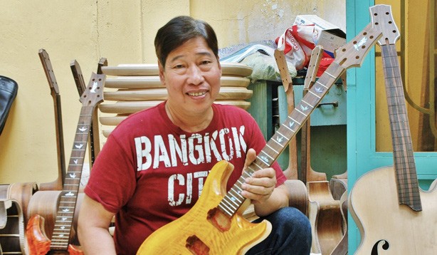 Nghệ nhân Ngọc Thức bên cây đàn ghita điện mà anh đang hoàn thiện. Ảnh: Trần Nguyễn Anh