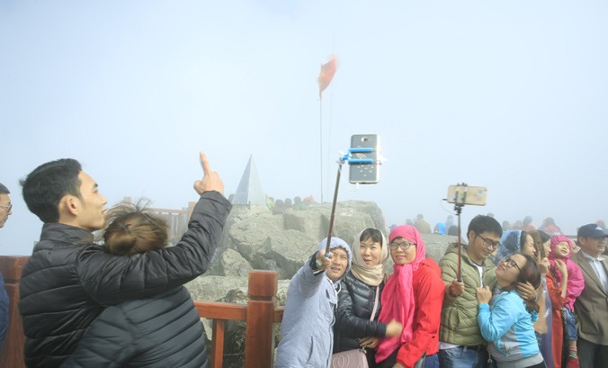 Các bạn trẻ chụp ảnh tự sướng trên đỉnh Fansipan. Ảnh: Hồng Vĩnh.