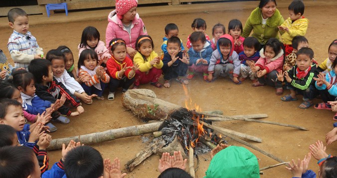 Các em học sinh mầm non ở bản Ngàm, xã Tam Thanh, huyện Quan Sơn (Thanh Hóa) ngồi sưởi ấm từ đống lửa cô giáo đốt lên. Ảnh: Hoàng Lam.