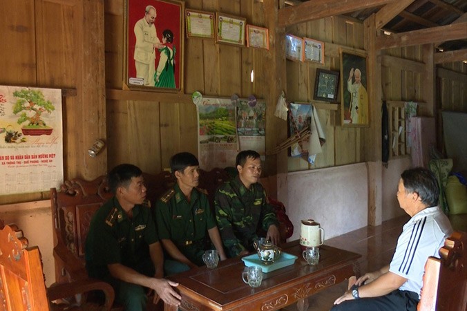 Thượng úy Nguyễn Văn Trinh (ngoài cùng bên phải) cùng đồng đội đang trao đổi công việc giúp đỡ người dân Lào với trưởng bản Nậm Táy. Ảnh: CTV.