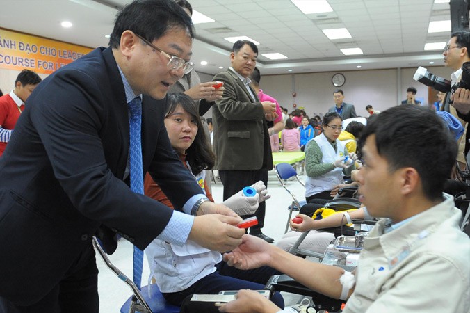Ông Bang Hyun Woo, Phó Tổng giám đốc Tổ hợp Samsung Việt Nam (người phía trong) và Tổng biên tập báo Tiền Phong Lê Xuân Sơn thăm hỏi, khích lệ và cảm ơn nhân viên, công nhân hiến máu. Ảnh: Xuân Tùng.