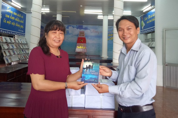Nhà báo Trương Hòa Hội tặng sách cho bà Phan Thị Thùy Giang, Giám đốc Thư viện TP Cần Thơ.