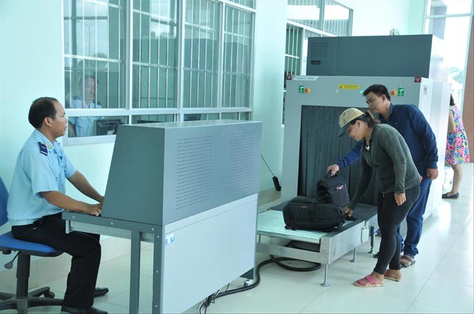 Hành khách cho hành lý đi qua máy soi chiếu của hải quan để kiểm tra. Ảnh: Tuấn Nguyễn.