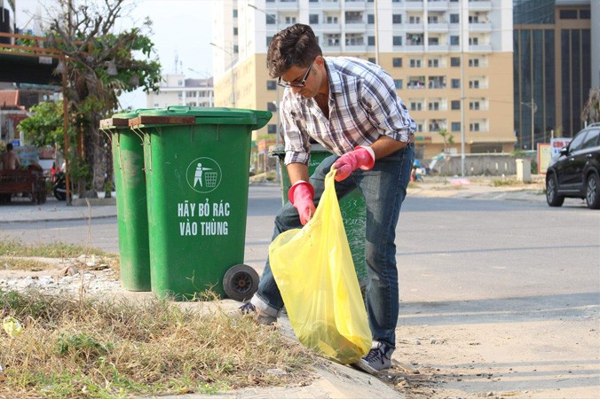 Hình ảnh chàng trai Mỹ cặm cụi nhặt rác rồi xách những túi rác to bỏ vào thùng rác đã trở nên quen thuộc với người dân ở khu An Thượng. Ảnh: Giang Thanh.