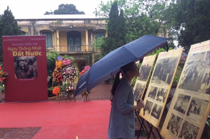 Người trẻ đội mưa xem triển lãm “Ngày thống nhất đất nước” hôm 25/4. Ảnh: Vi Khanh.