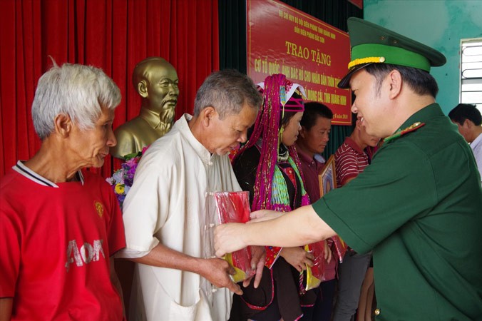 Đại tá Trần Văn Bừng, Chính ủy BĐBP Quảng Ninh trao tặng cờ Tổ quốc và ảnh Bác Hồ cho bà con thôn biên giới Thán Phún. Ảnh: P.Q