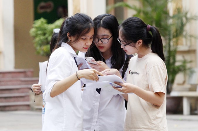 Thí sinh trao đổi sau khi thi tốt nghiệp THPT Quốc gia 2018 tại điểm thi Trường THCS Nguyễn Du, Hà Nội. Ảnh: Như Ý.