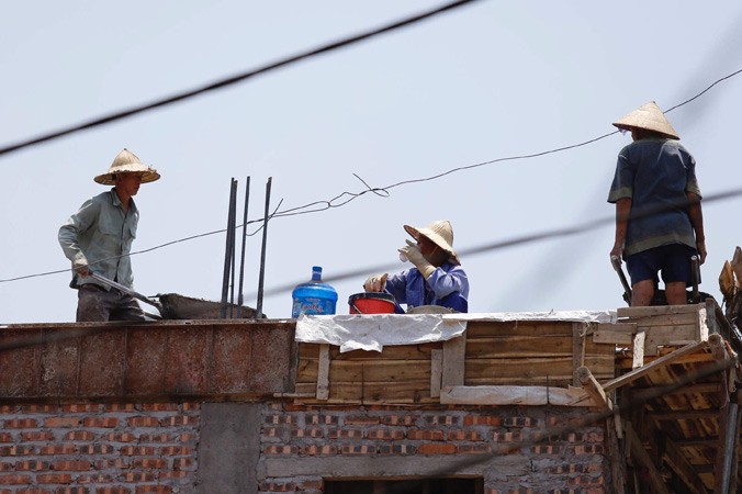 Những người thợ xây dựng đổ trần nhà dưới trời nắng nóng 45oC trên đường Nguyễn Trãi, Hà Nội. Ảnh: Như Ý.