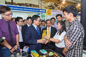 Hà Ngọc Châm (ngoài cùng, bên phải) trong một lần giới thiệu sản phẩm với Phó Thủ tướng Vũ Đức Đam tại một hội chợ. Ảnh: CTV