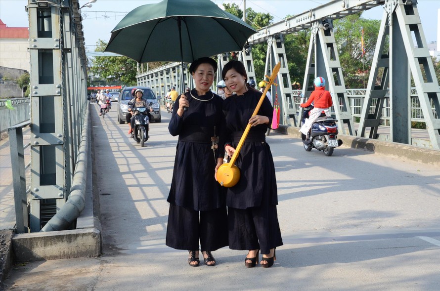 Bà Kiệm (bìa trái, cầm ô) trên đường về quê thăm, hiếu lễ với bố mẹ. Ảnh: Duy Chiến