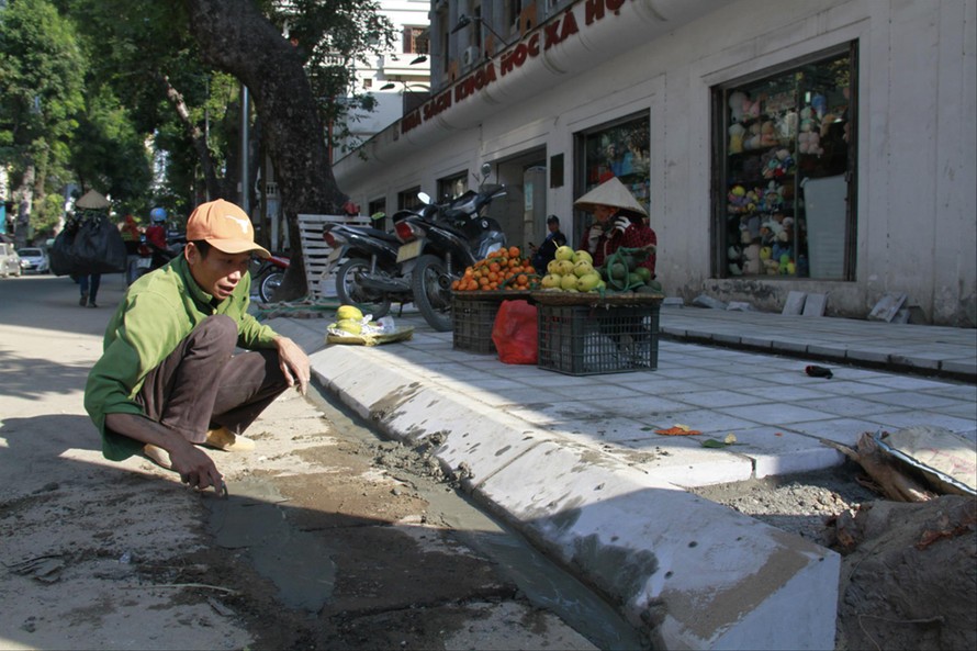 Công nhân thực hiện lát đá vỉa hè trên địa bàn quận Hai Bà Trưng Ảnh: Trường Phong 