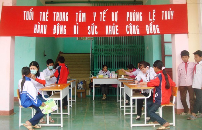 Nhân viên y tế tại Trung tâm y tế huyện Lệ Thủy khám bệnh cho học sinh ảnh: PV