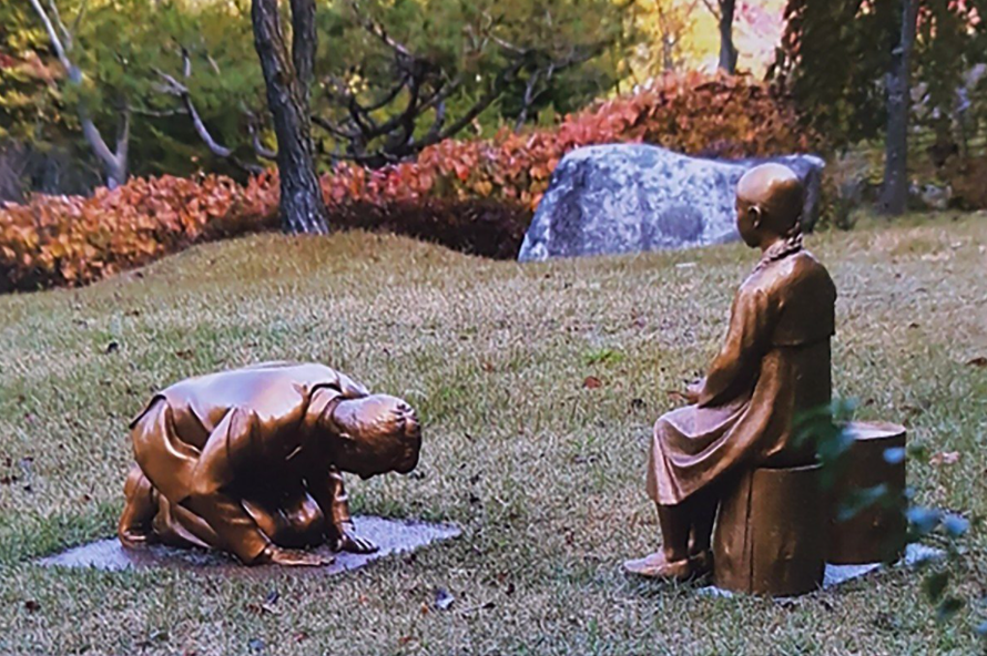 Bức tượng người đàn ông quỳ gối và cúi đầu trước cô gái trong thảo cầm viên ở Hàn Quốc. Ảnh: AP 