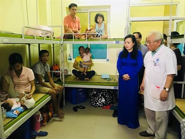 Bộ trưởng Nguyễn Thị Kim Tiến là ông Lê Thanh Hải, Giám đốc Bệnh viện Nhi Trung ương đi thăm bệnh nhi đang điều trị tại Bệnh viện. Ảnh: BV cung cấp