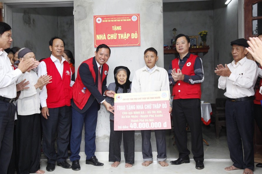 Đại diện lãnh đạo Hội Chữ thập đỏ Thành phố và lãnh đạo huyện Phú Xuyên trao tặng nhà Chữ thập đỏ tới người dân có hoàn cảnh khó khăn