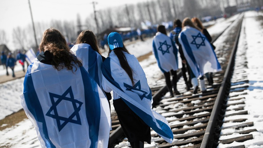 Người Israel choàng quốc kỳ lên người trong khi diễu hành trên đường ray ở trại diệt chủng Auschwitz khét tiếng của Phát xít Đức