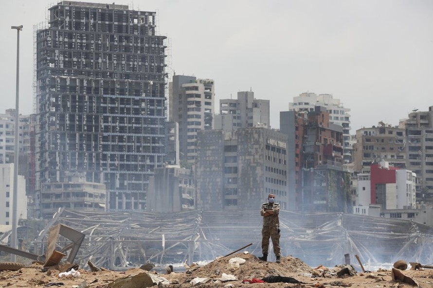 Một người lính đứng tại khu vực bị tàn phá bởi vụ nổ ở cảng Beirut (Ảnh: Reuters)