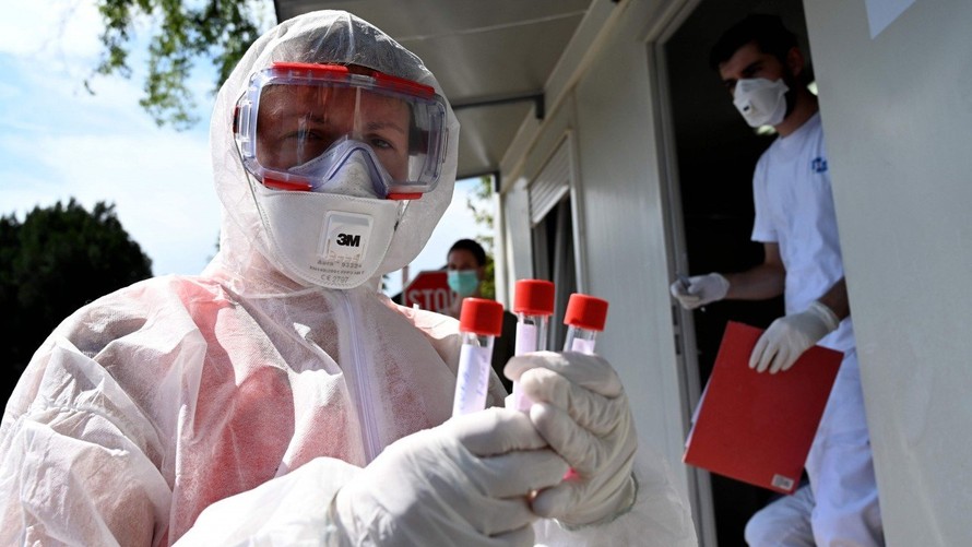 Một nhân viên y tế cầm các ống nghiệm có mẫu tăm bông tại trung tâm xét nghiệm COVID-19 ở Zagreb hôm thứ Hai. Ảnh: AFP